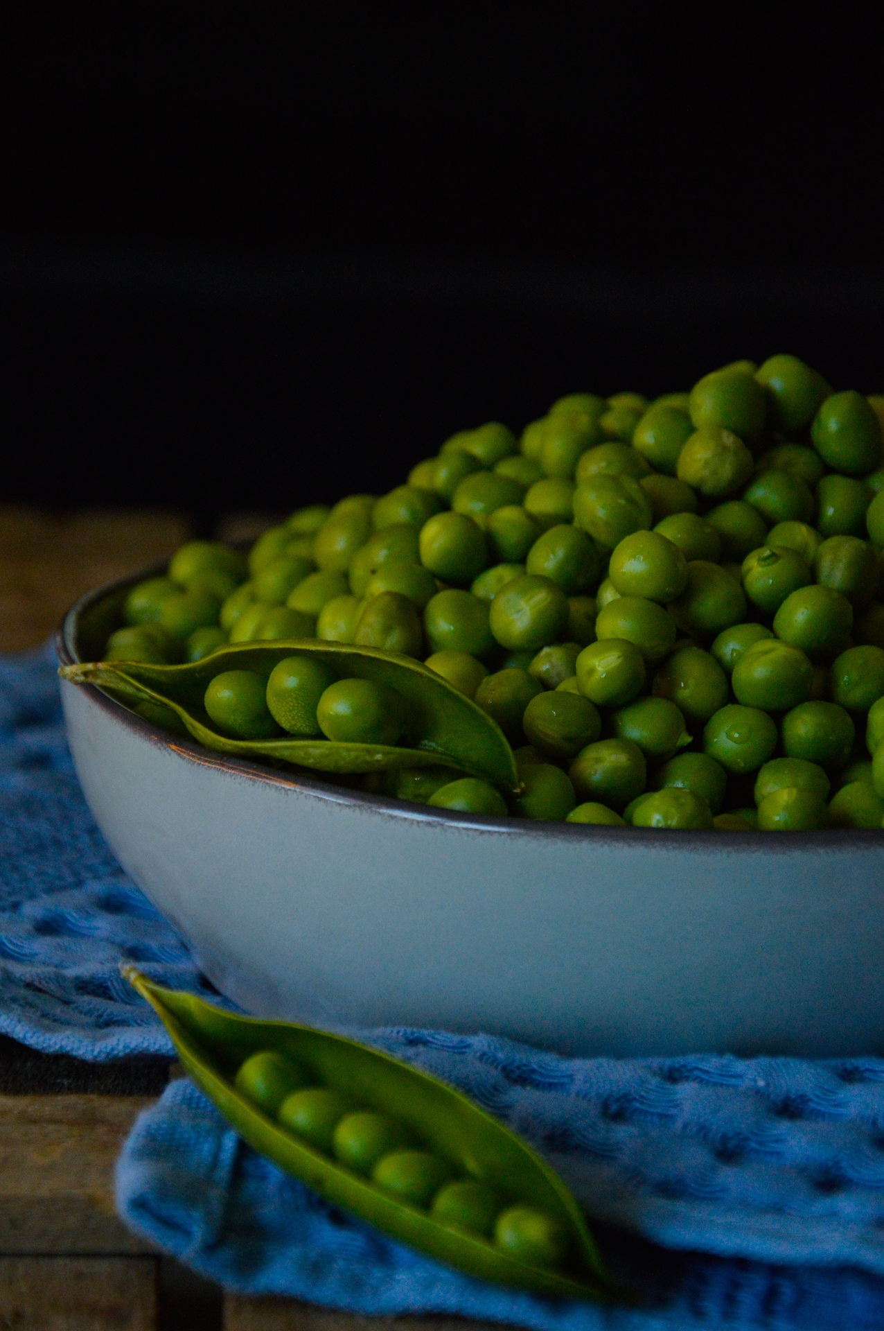 A pile of fresh green peas on a bright kitchen counter
